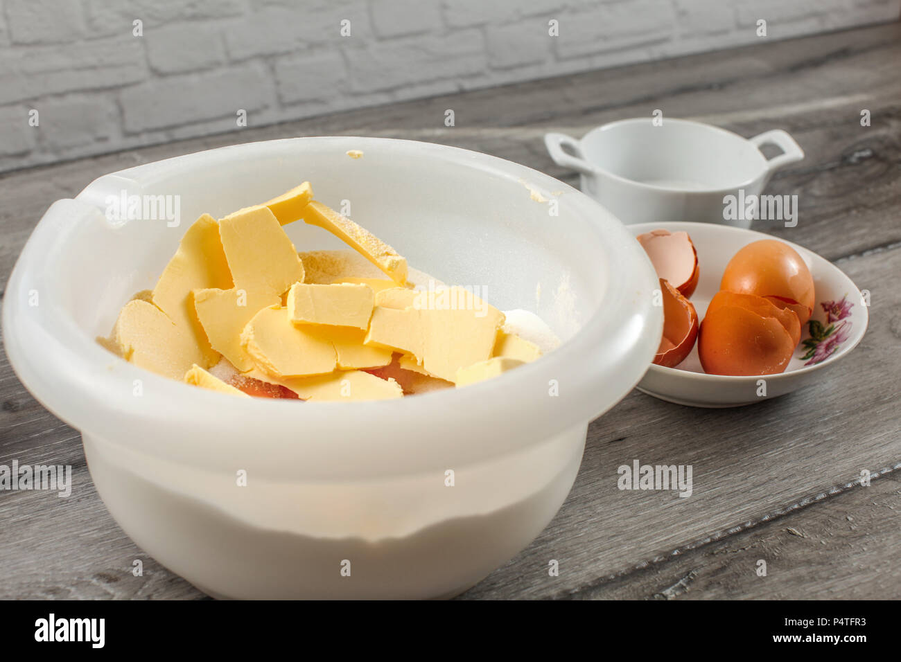 Bacinella di plastica bianca con burro, tuorlo d'uovo, la farina e il sale, pronto per essere mescolato - preparazione per la cottura di una torta. Foto Stock