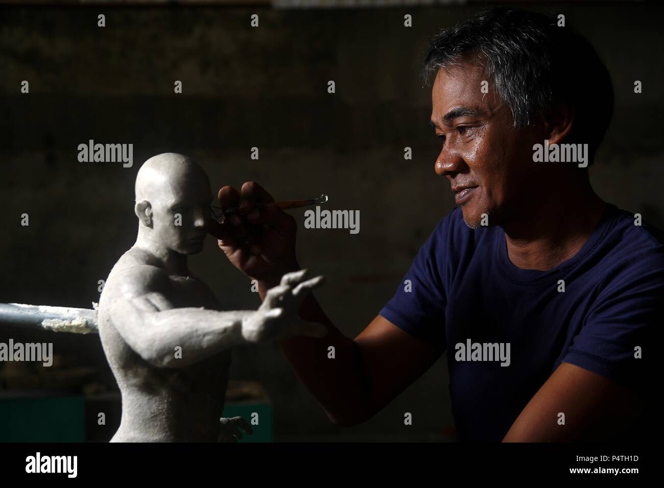 Foto di uno scultore lavorando su una statua Foto Stock