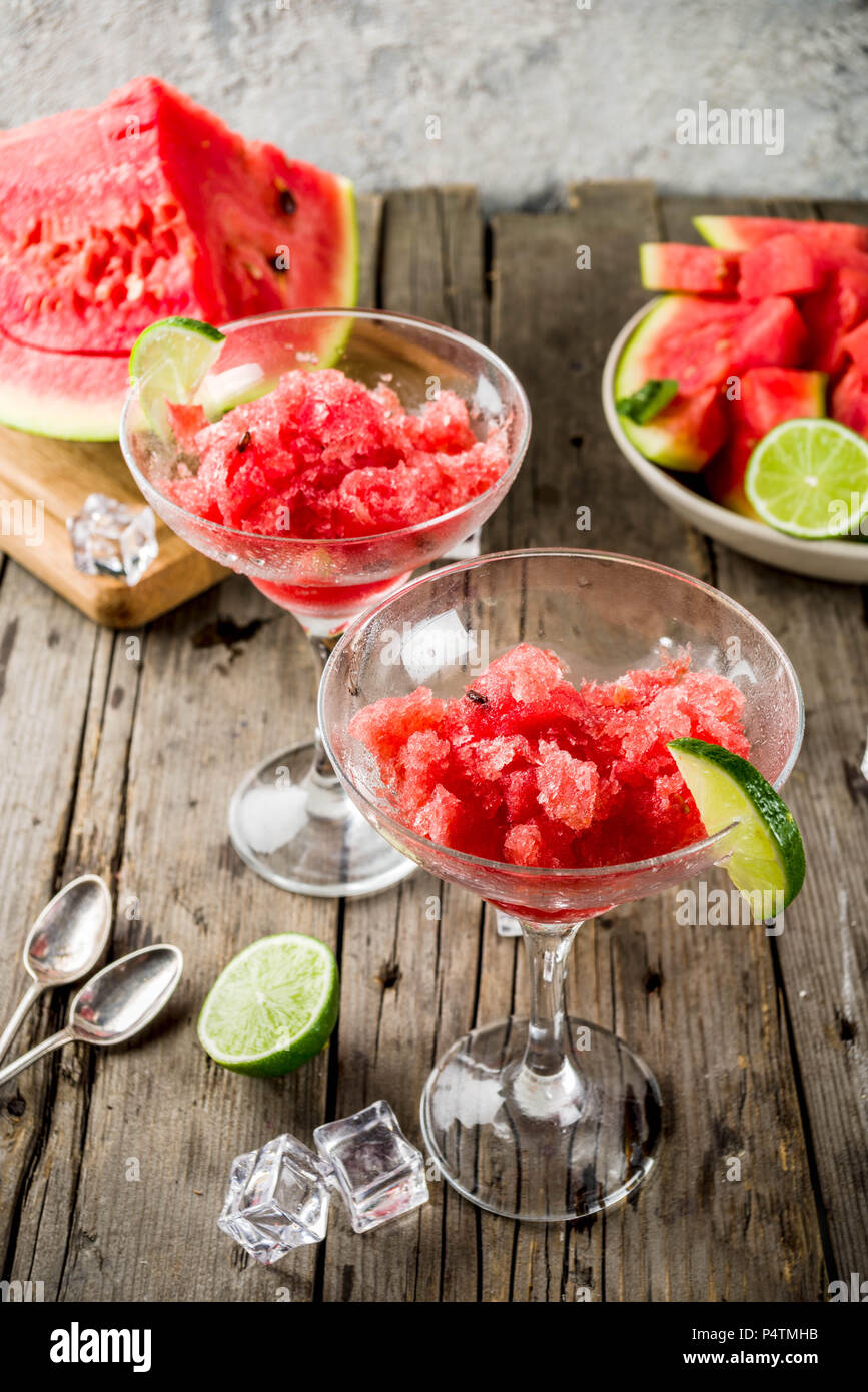 Dolce estate anguria e la calce e la granita con fette di anguria e menta, su marmo bianco di sfondo spazio di copia Foto Stock