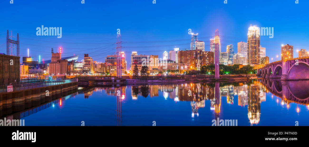 Lo skyline di Minneapolis con la riflessione nel fiume di notte. Foto Stock