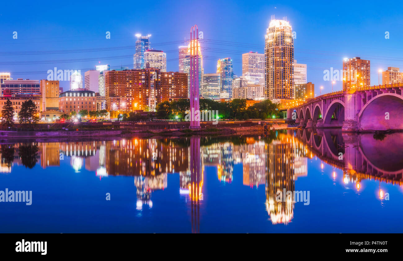 Lo skyline di Minneapolis con la riflessione nel fiume di notte. Foto Stock