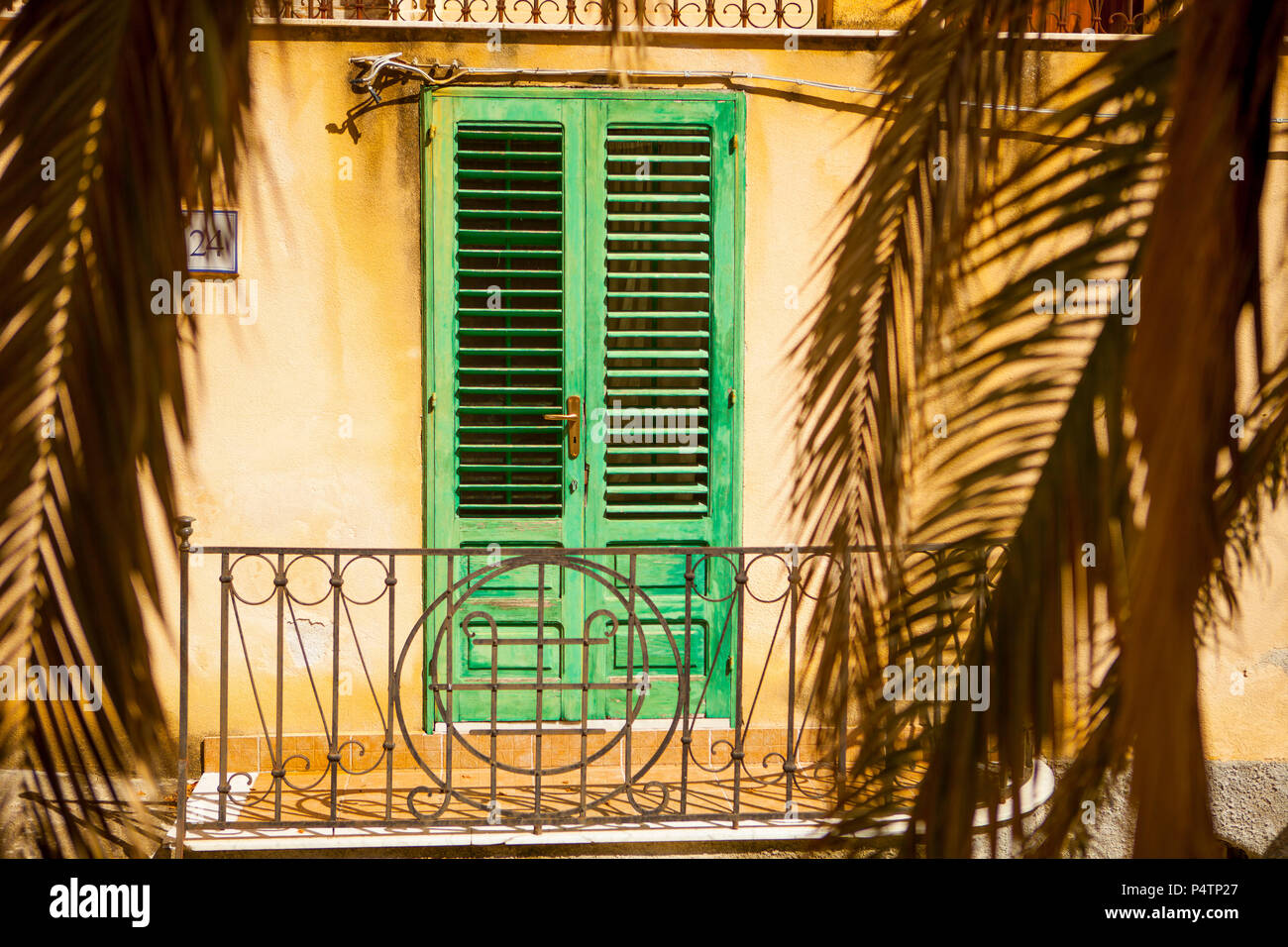 Lamella verde porta in una casa siciliana Foto Stock