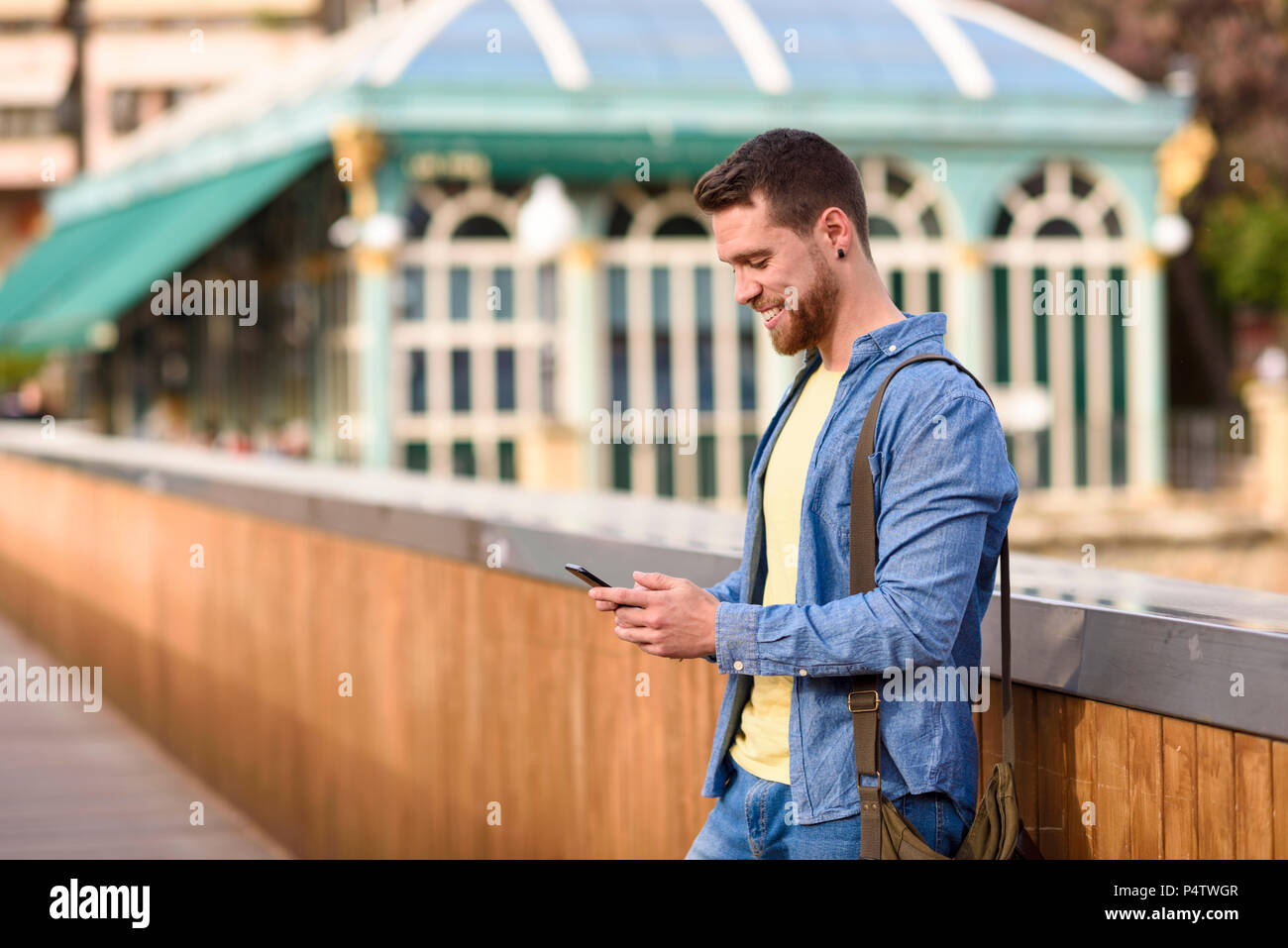 Giovane uomo che guarda il suo smartphone Foto Stock