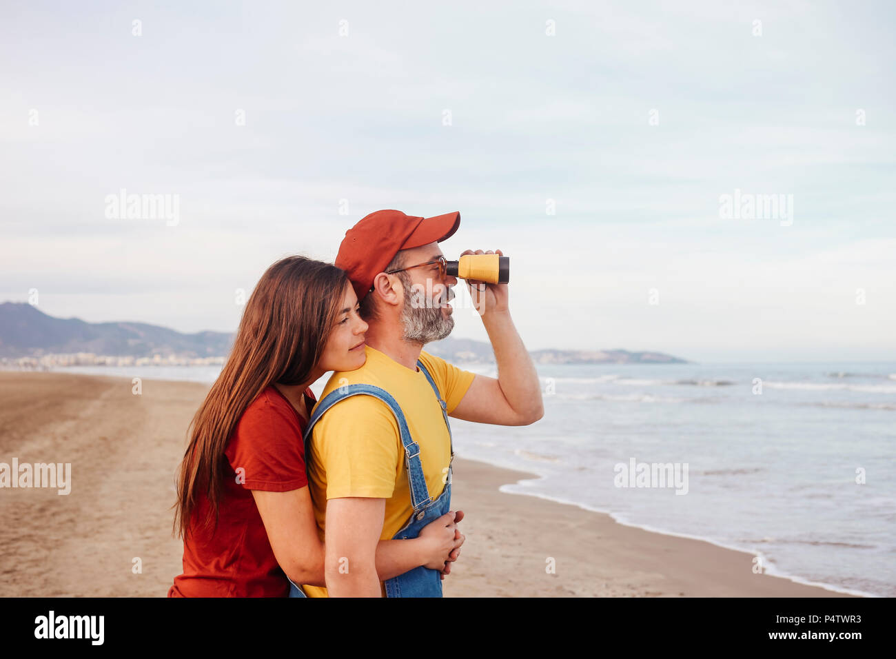Giovane con un binocolo sulla spiaggia Foto Stock