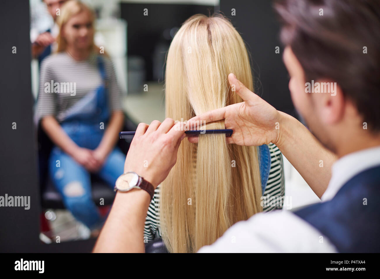 Vista posteriore del parrucchiere pettinatura donna capelli Foto Stock