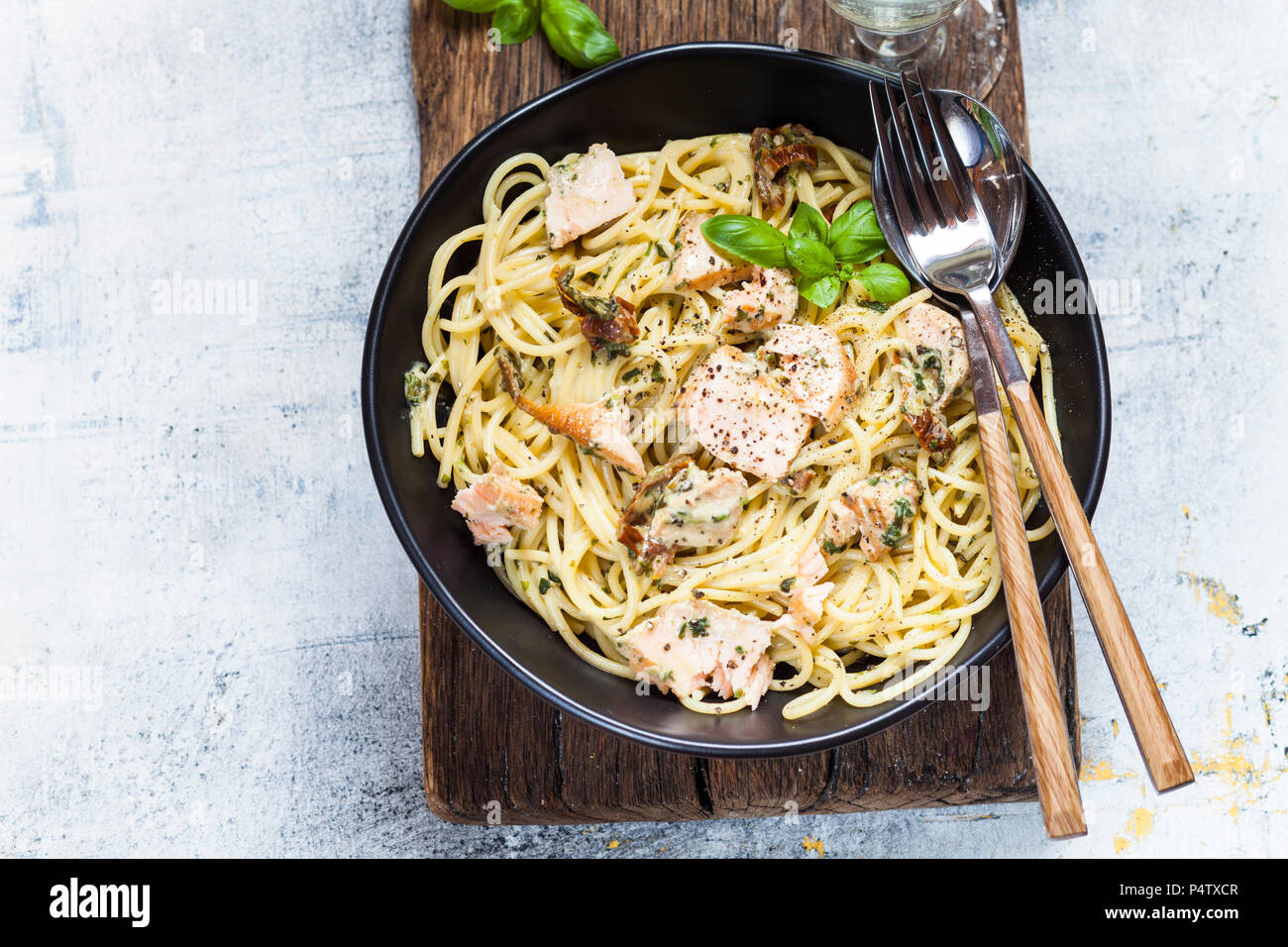Spaghetti con crema di spinaci, salsa di pomodori secchi e salmone Foto Stock