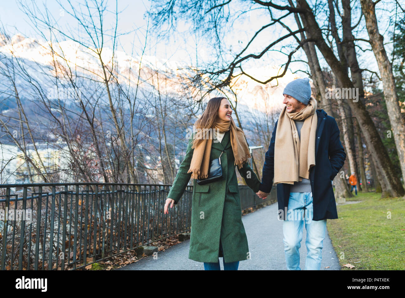Austria, Innsbruck, felice coppia giovane passeggiando insieme mano nella mano al tempo di inverno Foto Stock