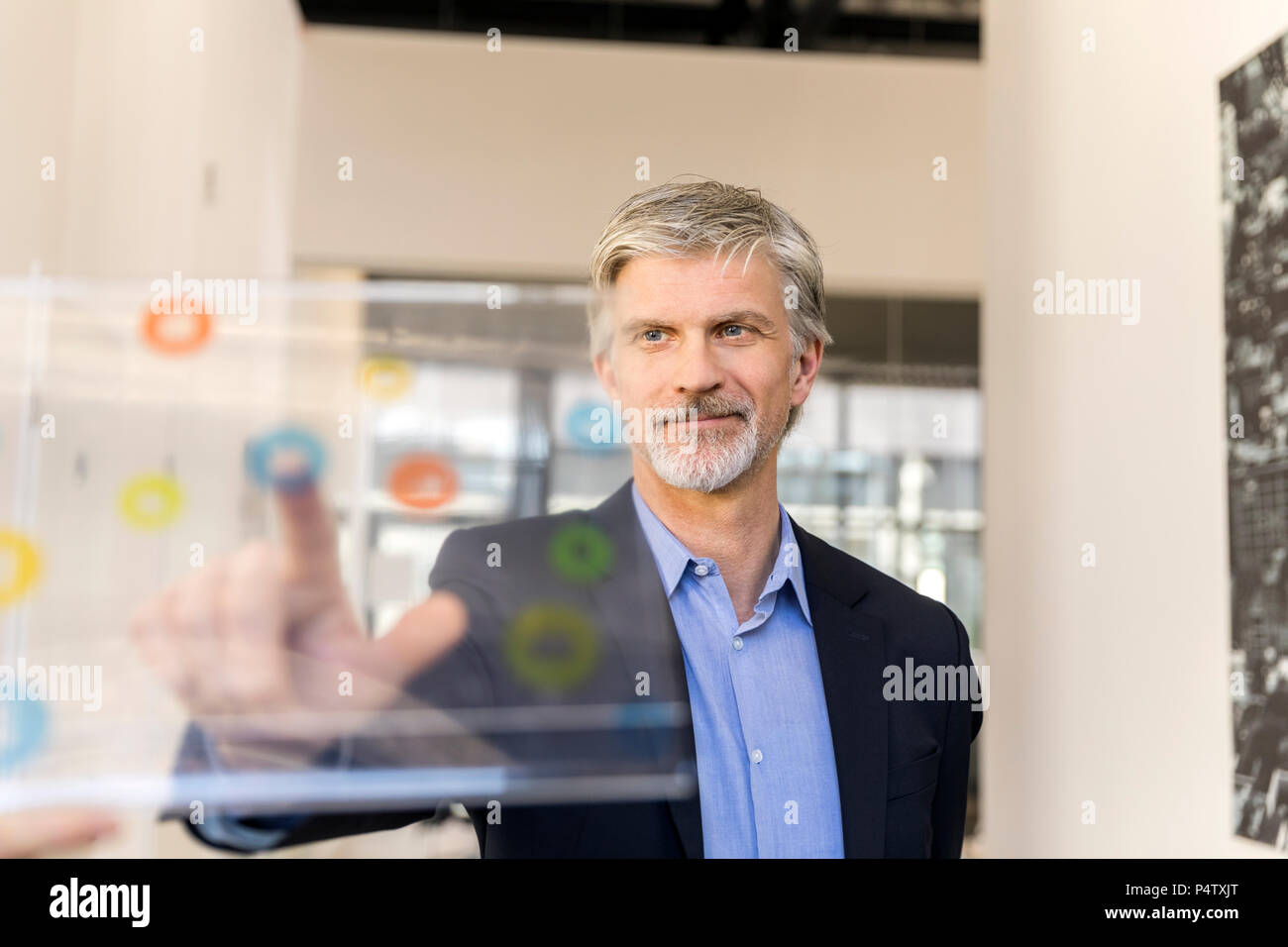 Imprenditore maturo utilizzando trasparente computer touchscreen Foto Stock