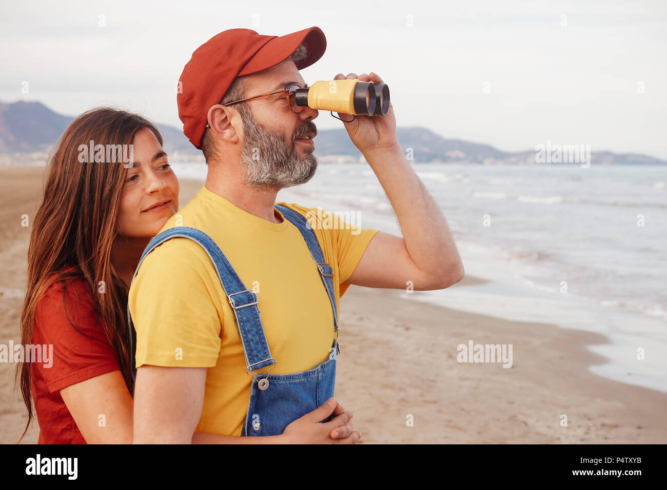 Giovane con un binocolo sulla spiaggia Foto Stock