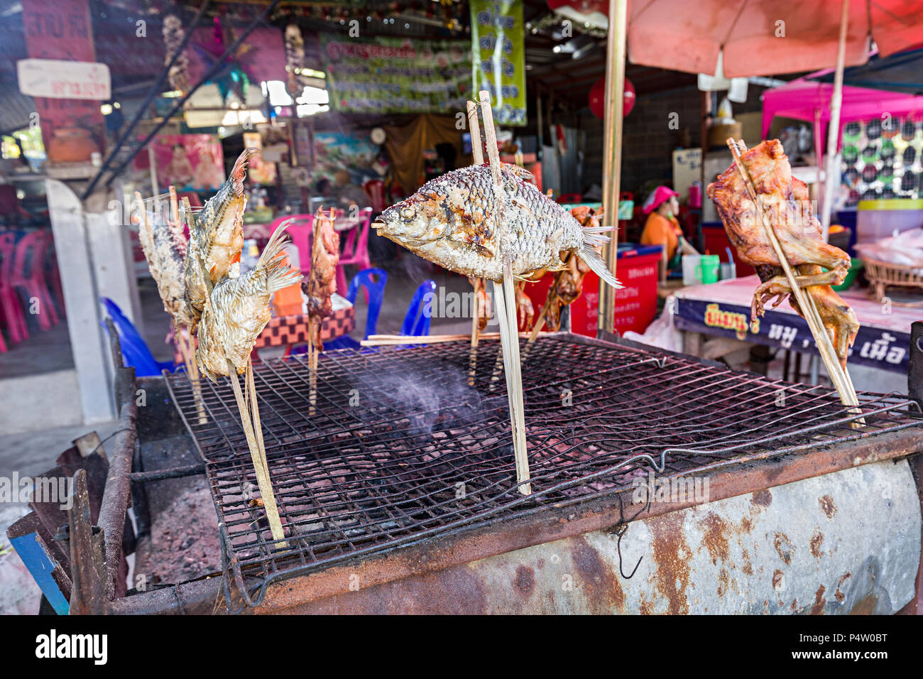 Pesce e cottura del pollo sulla griglia in banchina, attraversamento frontiera Laos Foto Stock