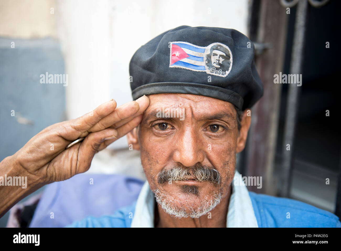 Patriota cubano saluta; uomo indossa un cappello con una bandiera cubana e  immagine di Che Guevara; tenendo una moneta nel palmo della mano. L'Avana,  Cuba Foto stock - Alamy
