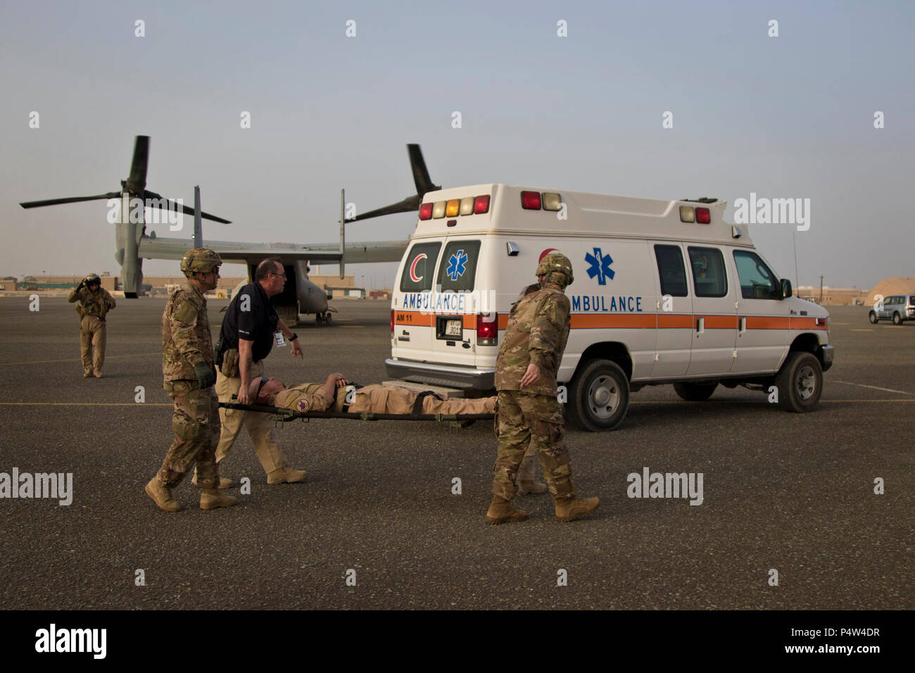 Stati Uniti Army combat medics, con la 86combattere ospedale di supporto e di assistenza medica di emergenza tecnici, con area Support Group - Kuwait comune servizio di emergenza, eseguire una simulazione di incidente off di un MV-22 Osprey durante una formazione congiunta di esercitare con Marines dal mezzo marino Tiltrotor squadrone - 364 (VMM-364), a Camp Arifjan, Kuwait, 8 maggio 2017. Foto Stock