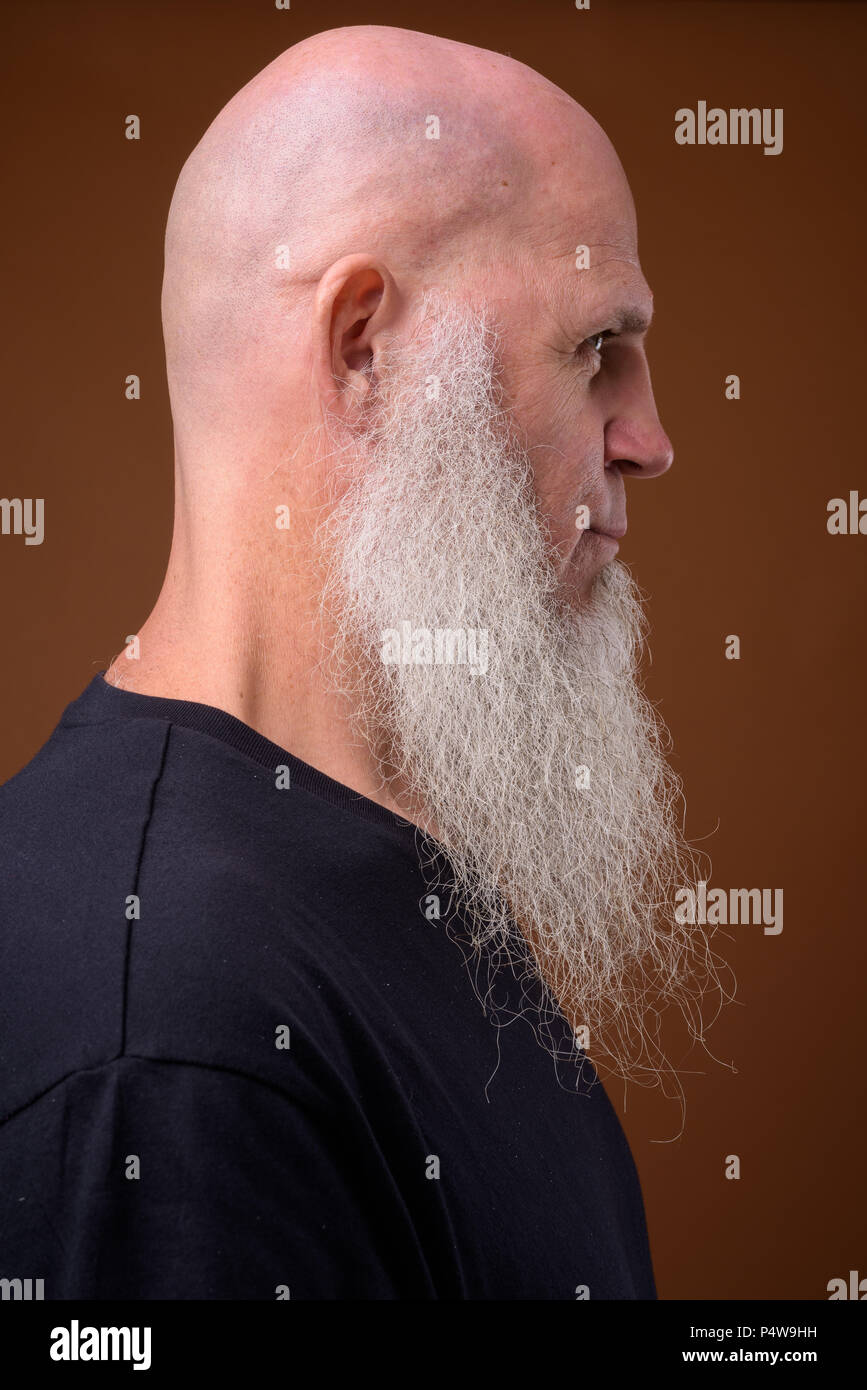 Coppia uomo calvo con una lunga barba grigia contro sfondo marrone Foto Stock