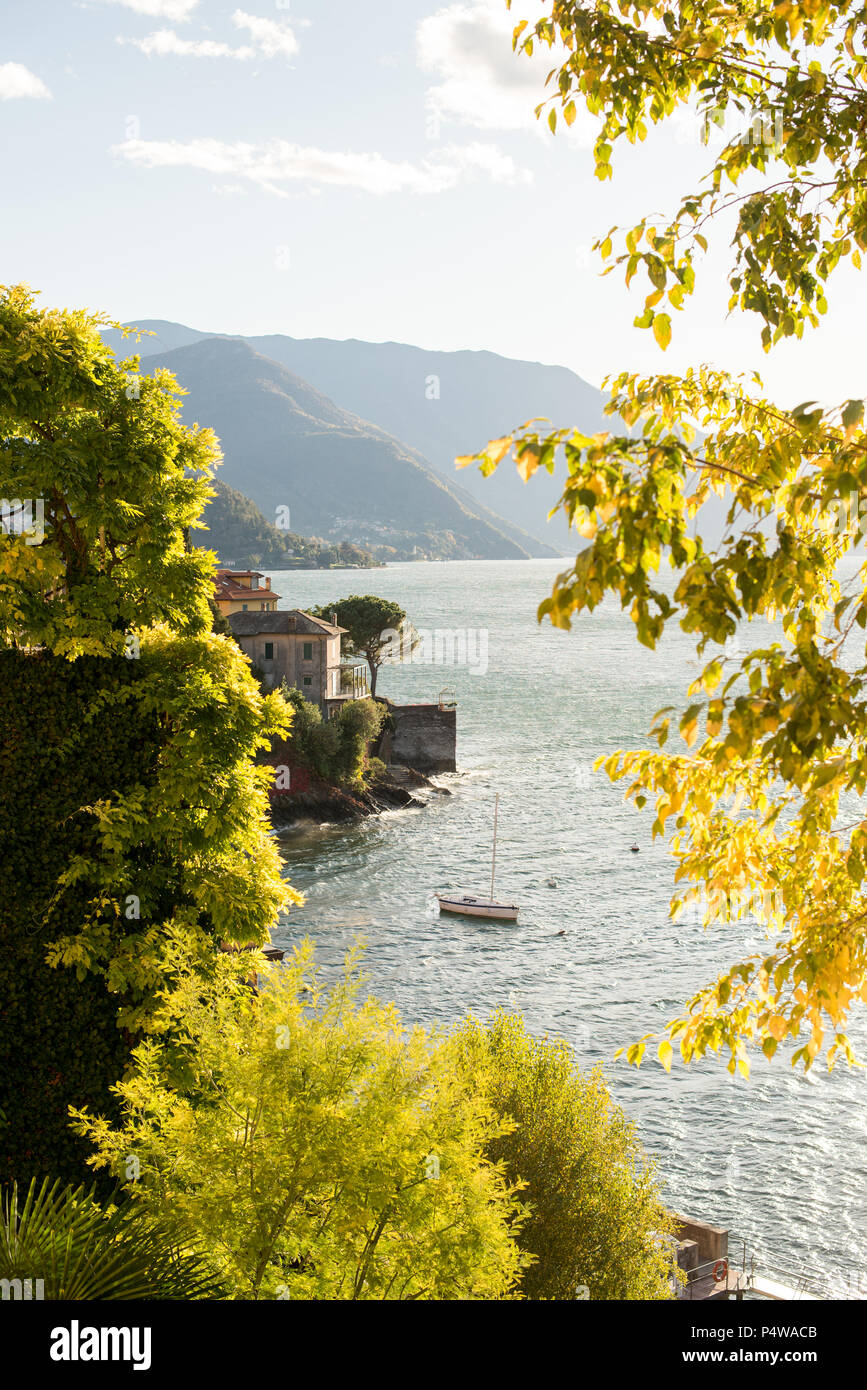 Il lago di Como in Italia. Tramonto panoramico vista con barca e antica Villa. Foto Stock