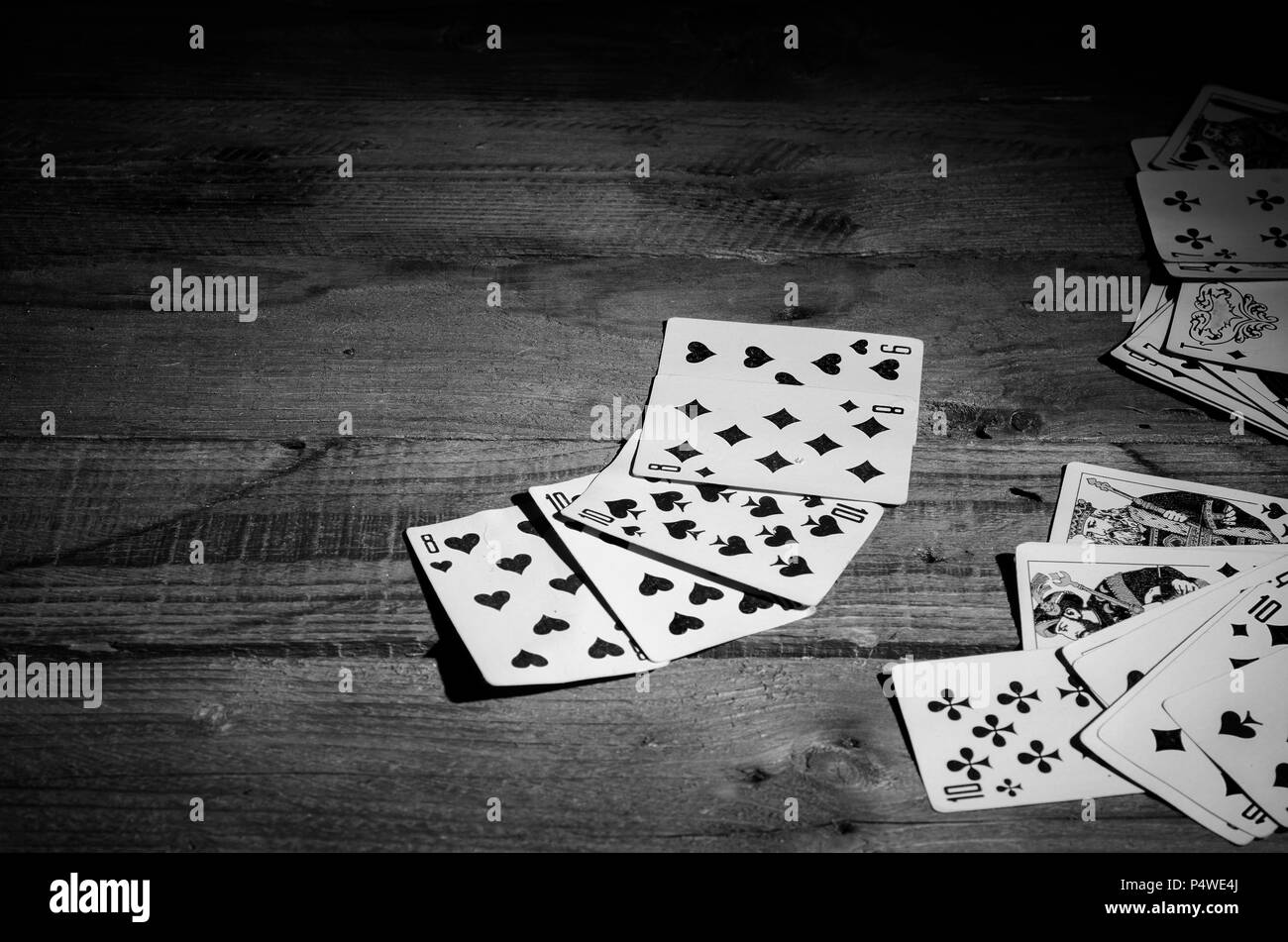 Carte da gioco su un tavolo di legno in bianco e nero. Foto Stock