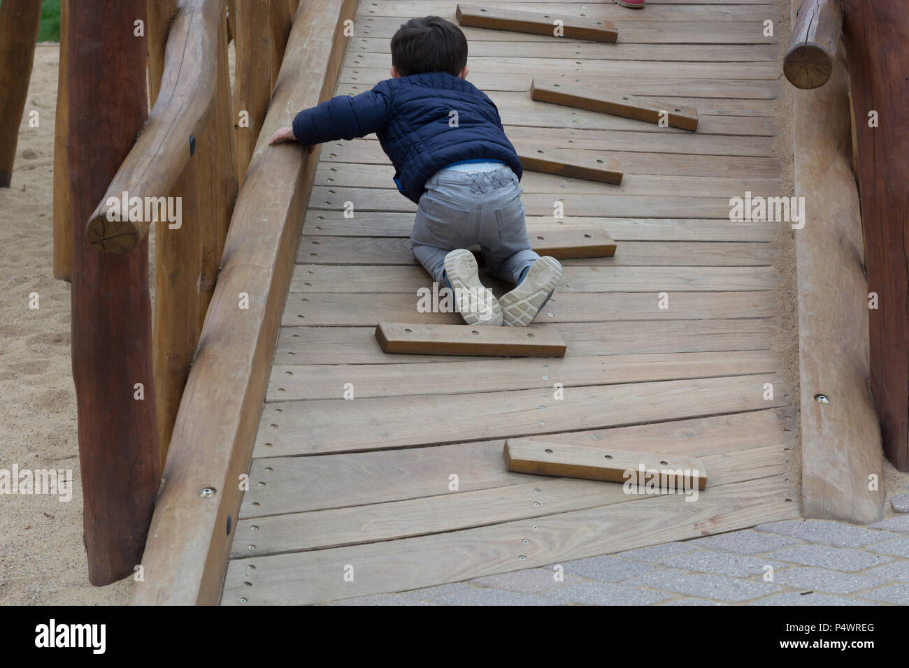 Felice bambino divertirsi su un telaio di arrampicata outdoor Foto Stock