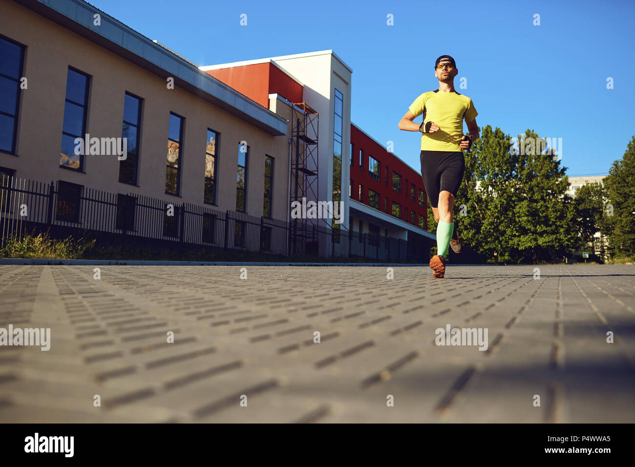 Un uomo sportivo corre attraverso le strade della città Foto Stock