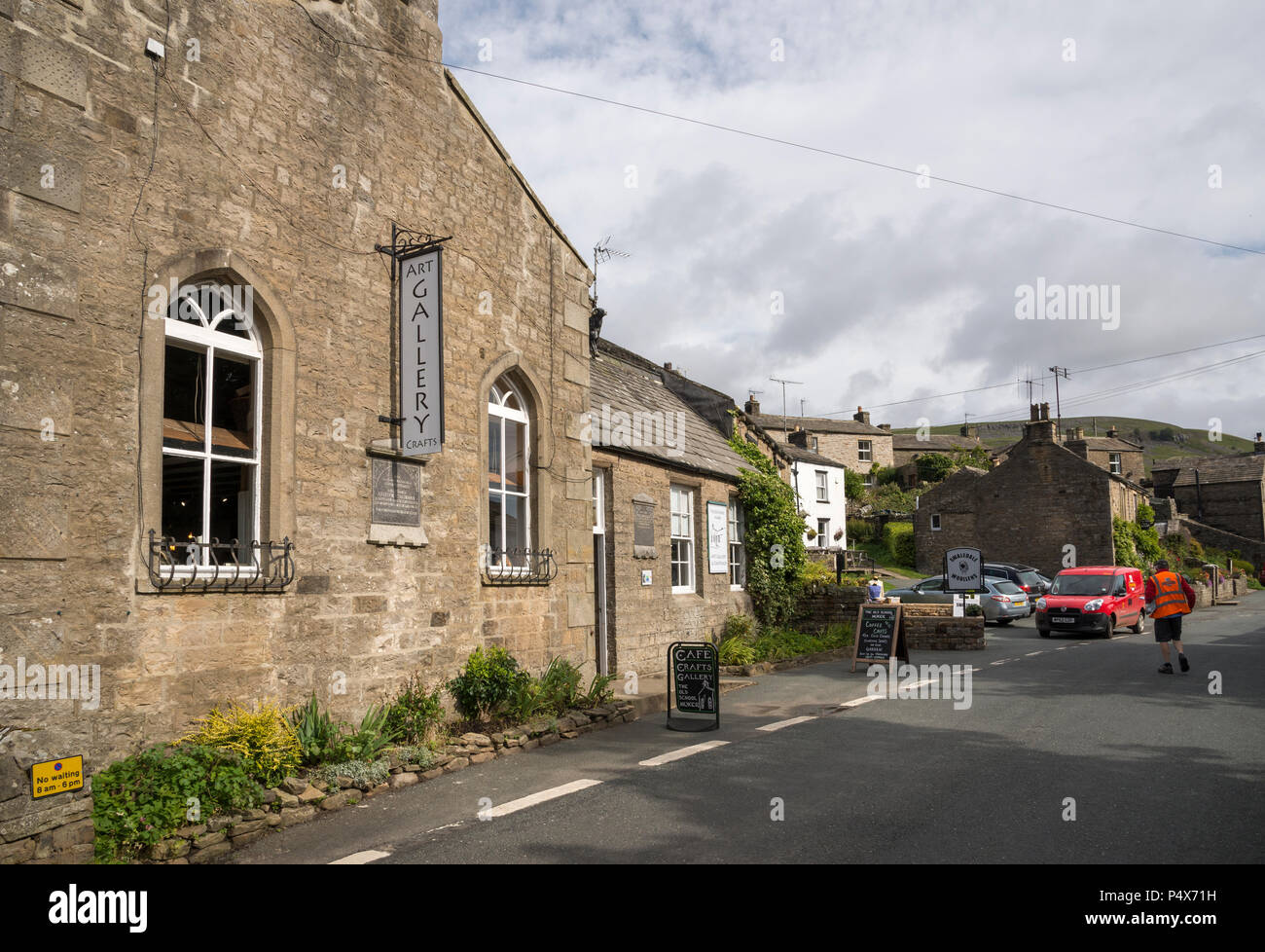 La vecchia scuola casa del villaggio di Muker, Swaledale, North Yorkshire. Ora una galleria d'arte. Portalettere consegna in un piccolo furgone rosso. Foto Stock
