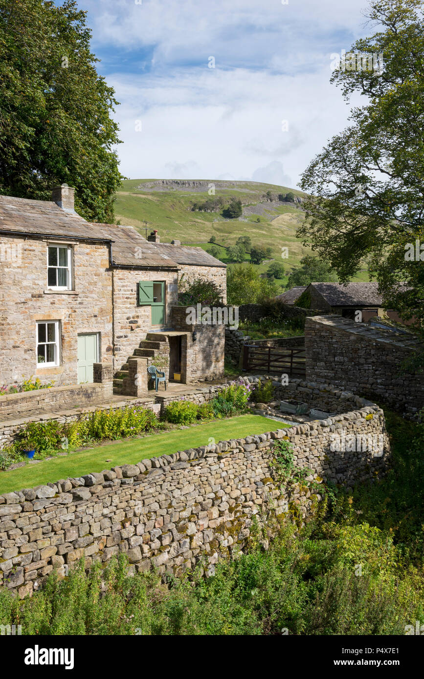 Cottage accanto al fiume Swale nel villaggio di Muker, Swaedale, North Yorkshire, Inghilterra. Foto Stock