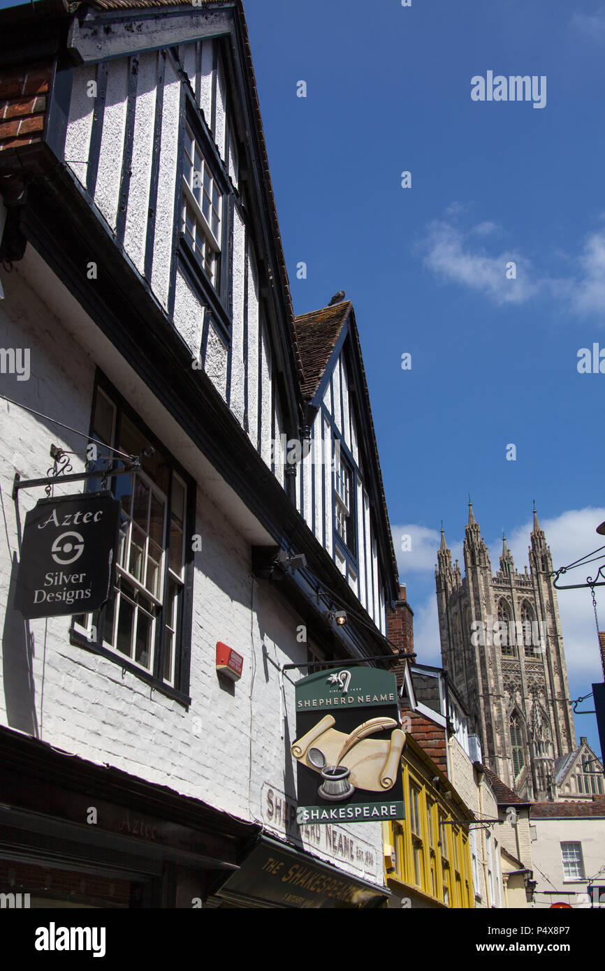 Città di Canterbury, Inghilterra. Shop e pub su fronti di Canterbury norcineria Lane, con la Cattedrale di Canterbury e il campanile a torre di Harry in background. Foto Stock
