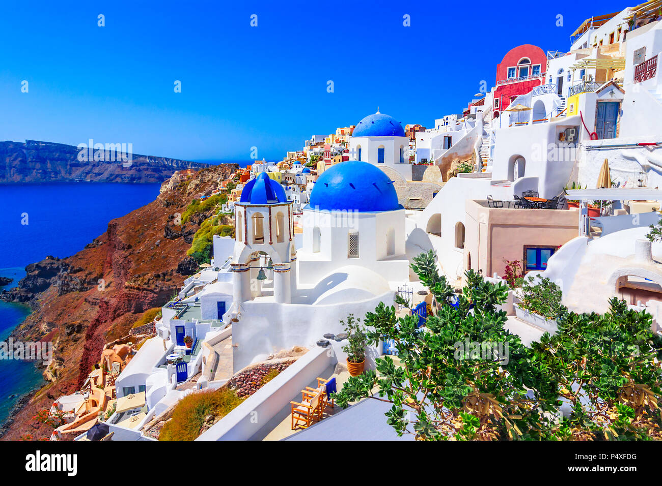 La cittadina di Oia - Santorini Island, Grecia al tramonto. Tradizionale e famose case bianche e chiese con le cupole blu sulla Caldera, il mare Egeo. Foto Stock