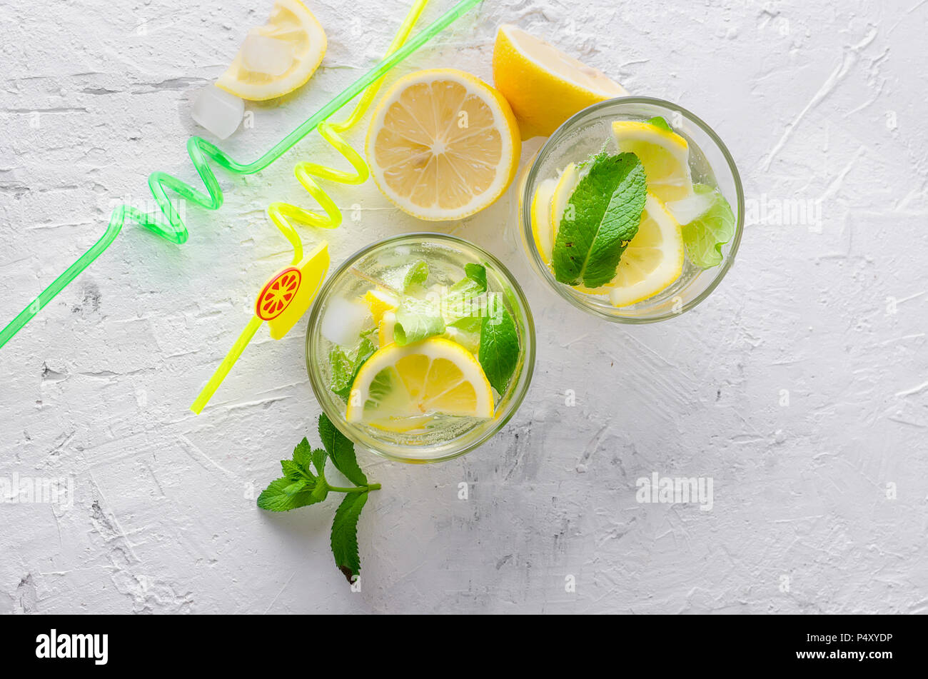 Freddo fresco cocktail mojito con soda e limone in vetro e ingredienti su uno sfondo luminoso Foto Stock