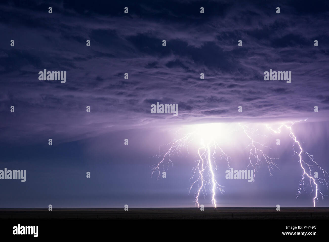 Il fulmine colpisce e illumina le nubi drammatiche della tempesta durante una tempesta estiva vicino a Eads, Colorado Foto Stock