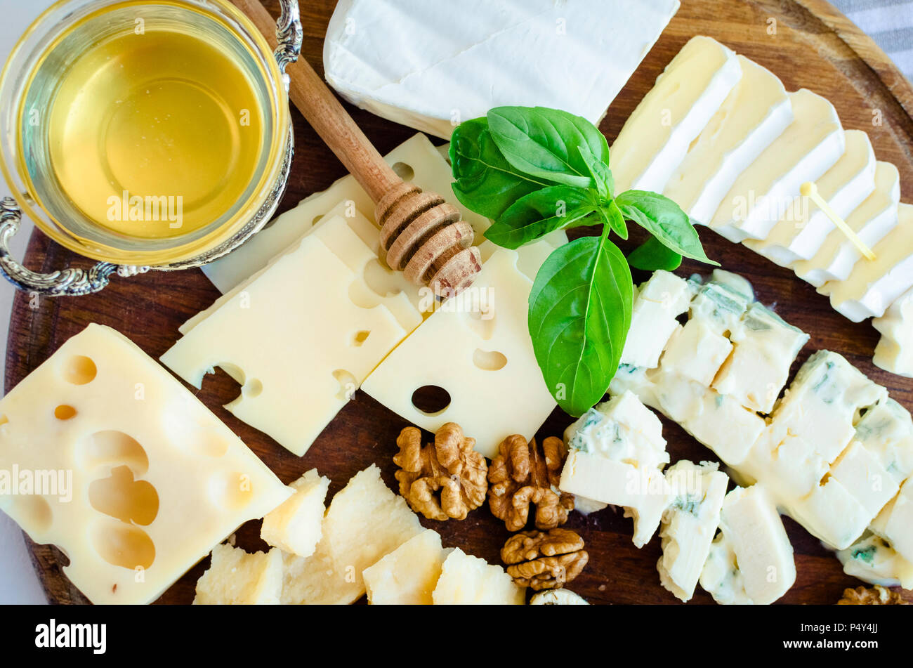 Vassoio di formaggi: Parmigiano, Cheddar, gouda, gorgonzola, Brie e altri  con noci e miele sulla tavola di legno su sfondo bianco. Antipasti gustosi  con Foto stock - Alamy