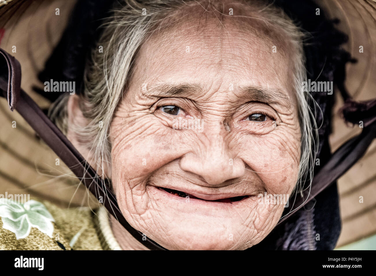 Il vecchio donna gentile con il vietnamita cappello di paglia Foto Stock