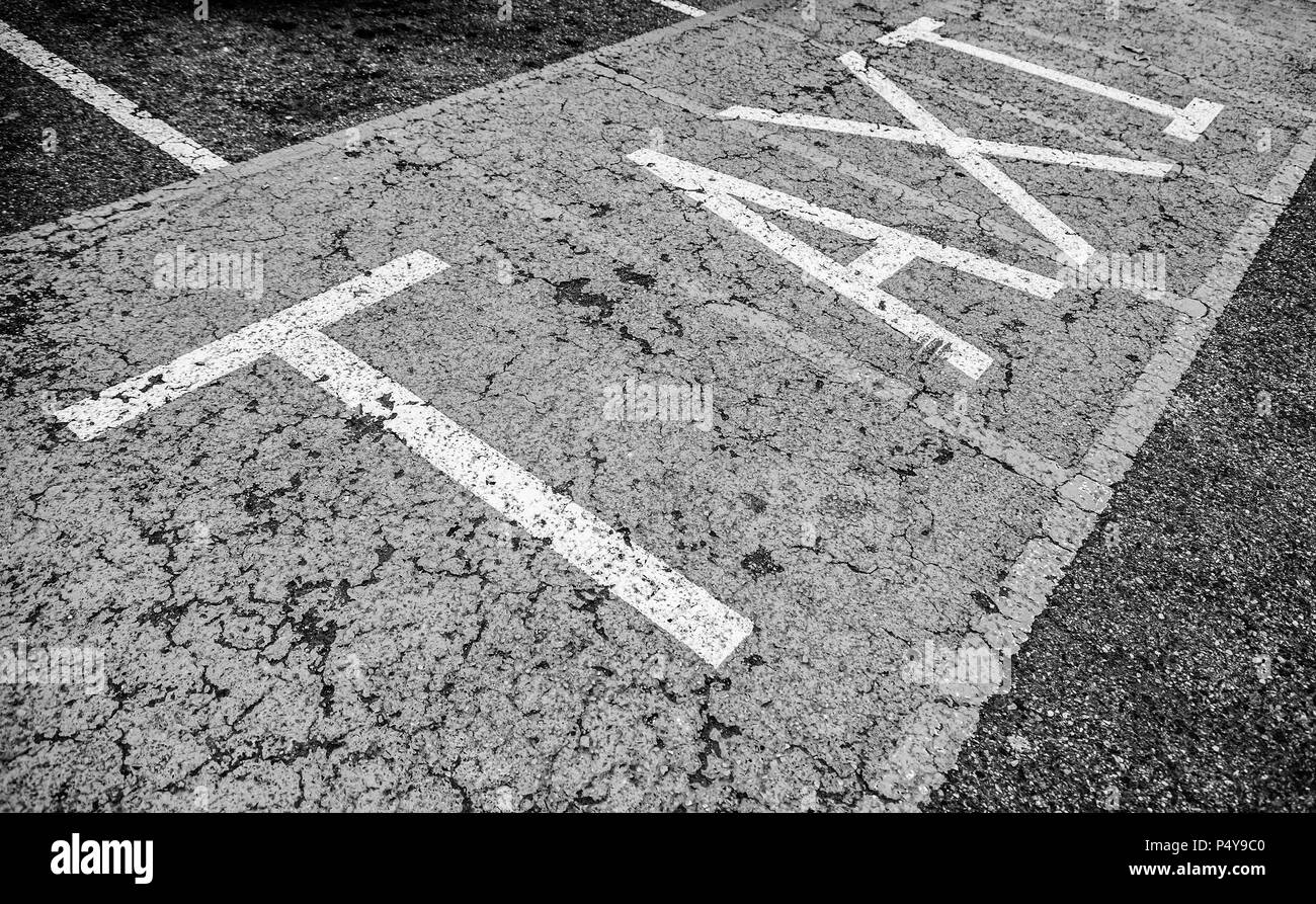 Segno di taxi su asfalto, dettaglio dipinte di un giallo cartello stradale e informazioni sulla sicurezza Foto Stock