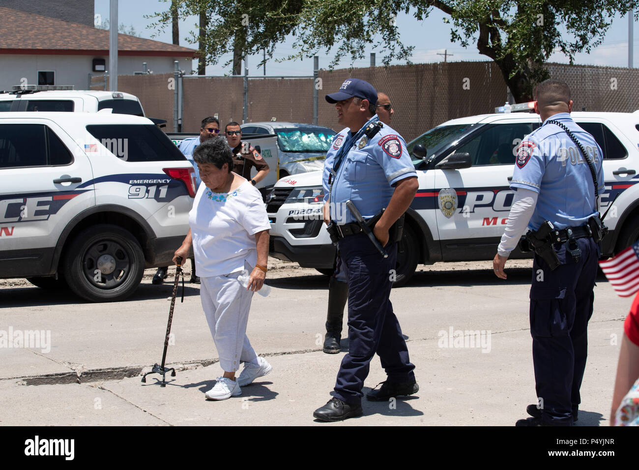 Stati Uniti Pattuglia di Confine e McAllen Guardia di polizia un immigrato centro di detenzione mentre i manifestanti blocco un governo bus con figli di immigrati a bordo per tenerlo da lasciare. Foto Stock