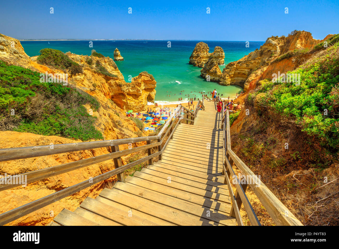Passerella in legno per scenic Praia do Camilo di Lagos costa, Algarve, Portogallo. Le lunghe scale per acque chiare di Algarve. Vacanze estive in Europa. Foto Stock