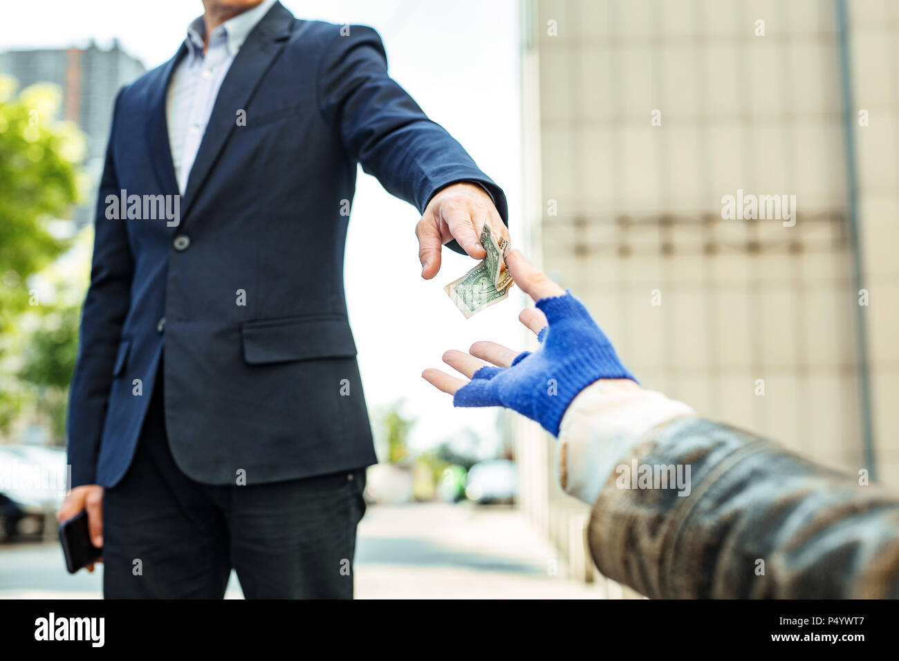 Collare bianco lavoratore dando dollaro per senzatetto vagabonda Foto Stock