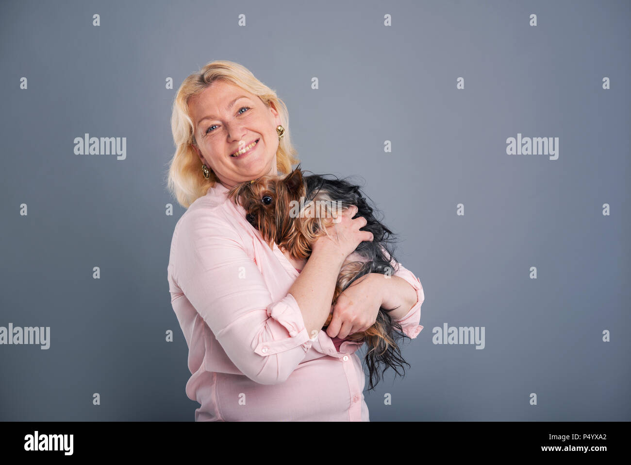 Felice donna di mezza età cuddling con il suo cane Foto Stock
