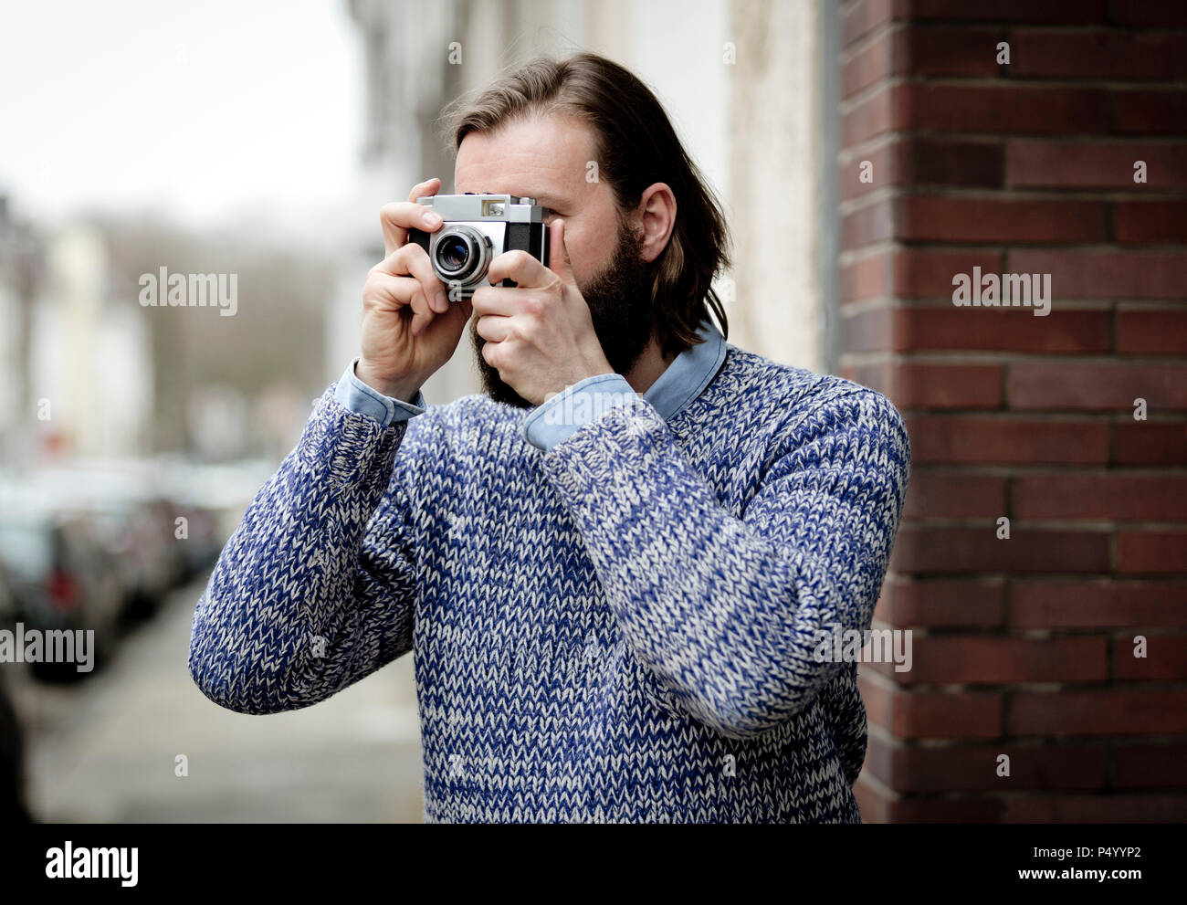 Uomo con la barba di scattare le foto con la vecchia macchina fotografica Foto Stock