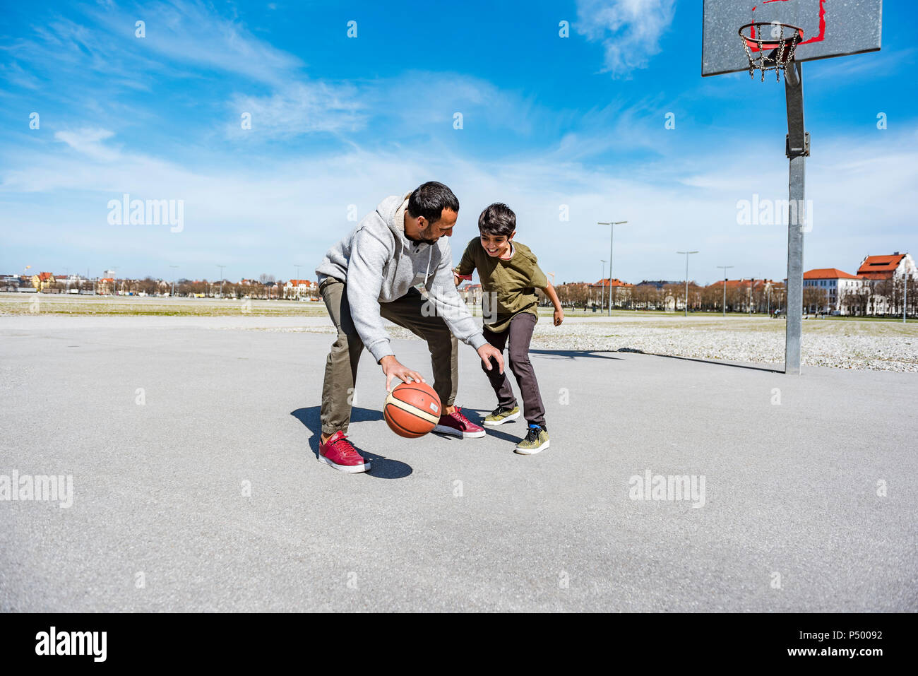 Padre e figlio giocare a basket sulla corte all'aperto Foto Stock