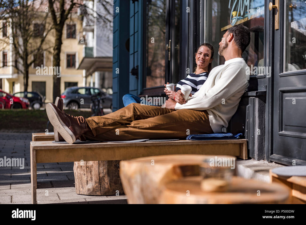 L uomo e la donna seduta al di fuori di un cafe parlando Foto Stock