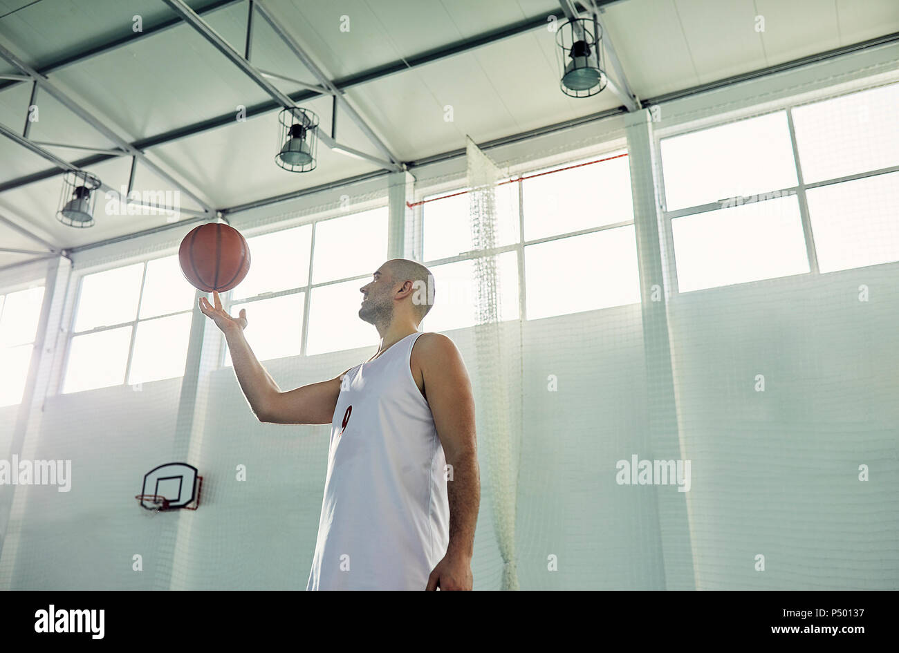 L'uomo gioca con la pallacanestro, interni Foto Stock