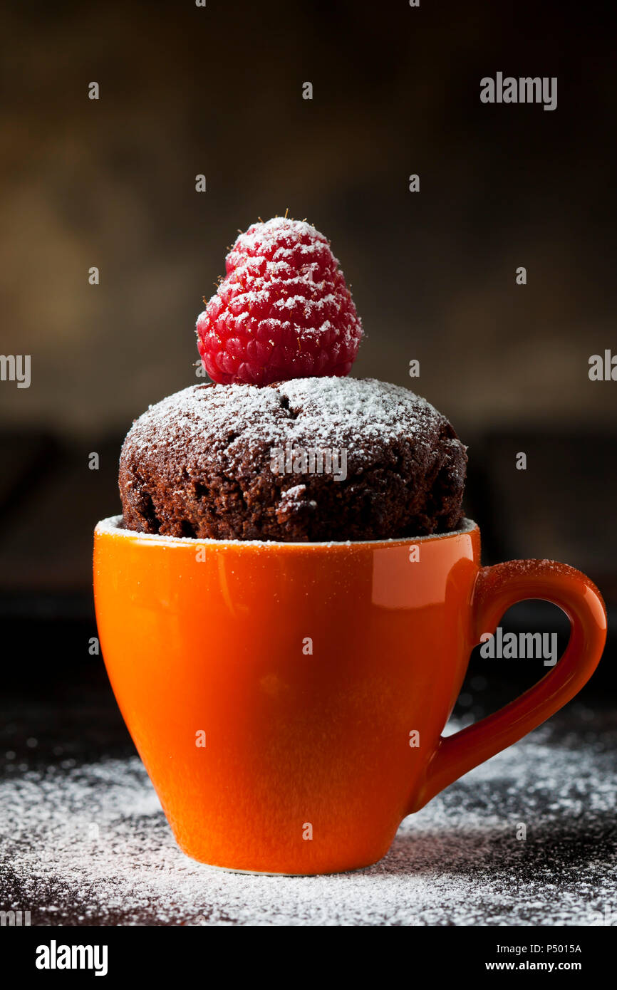 Tazza di cioccolato torta con lo zucchero a velo e lampone Foto Stock