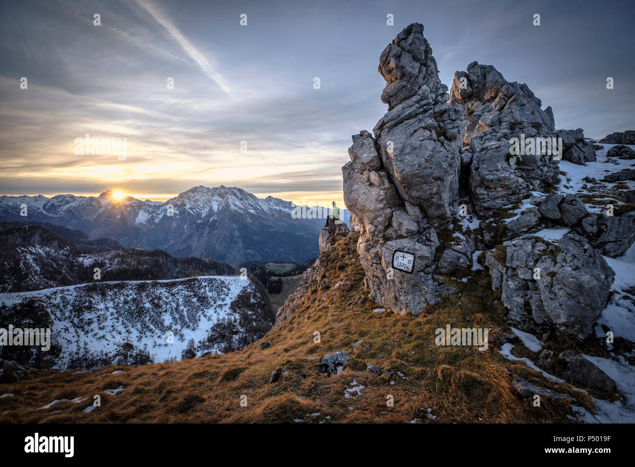 In Germania, in Baviera, sulle Alpi di Berchtesgaden, vista Schneibstein, escursionista seduta sul punto di visualizzazione al tramonto Foto Stock