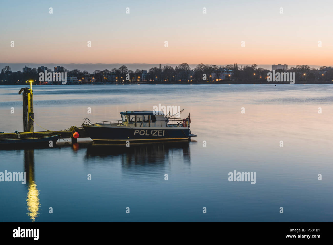 Germania, Hamburg Alster esterno ed il lago, area di ormeggio, barca di polizia al mattino Foto Stock