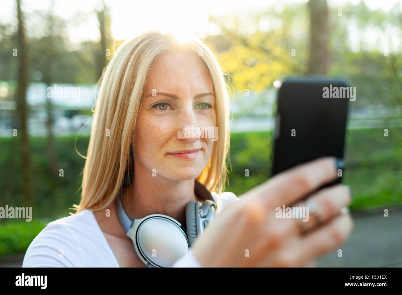 Ritratto di donna bionda tenendo selfie con lo smartphone Foto Stock