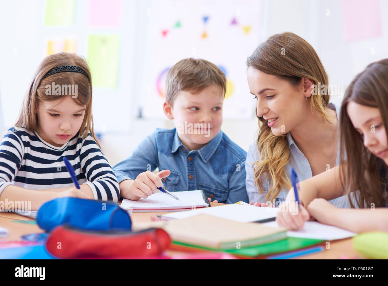 Docente aiutare gli studenti con i loro compiti in classe Foto Stock