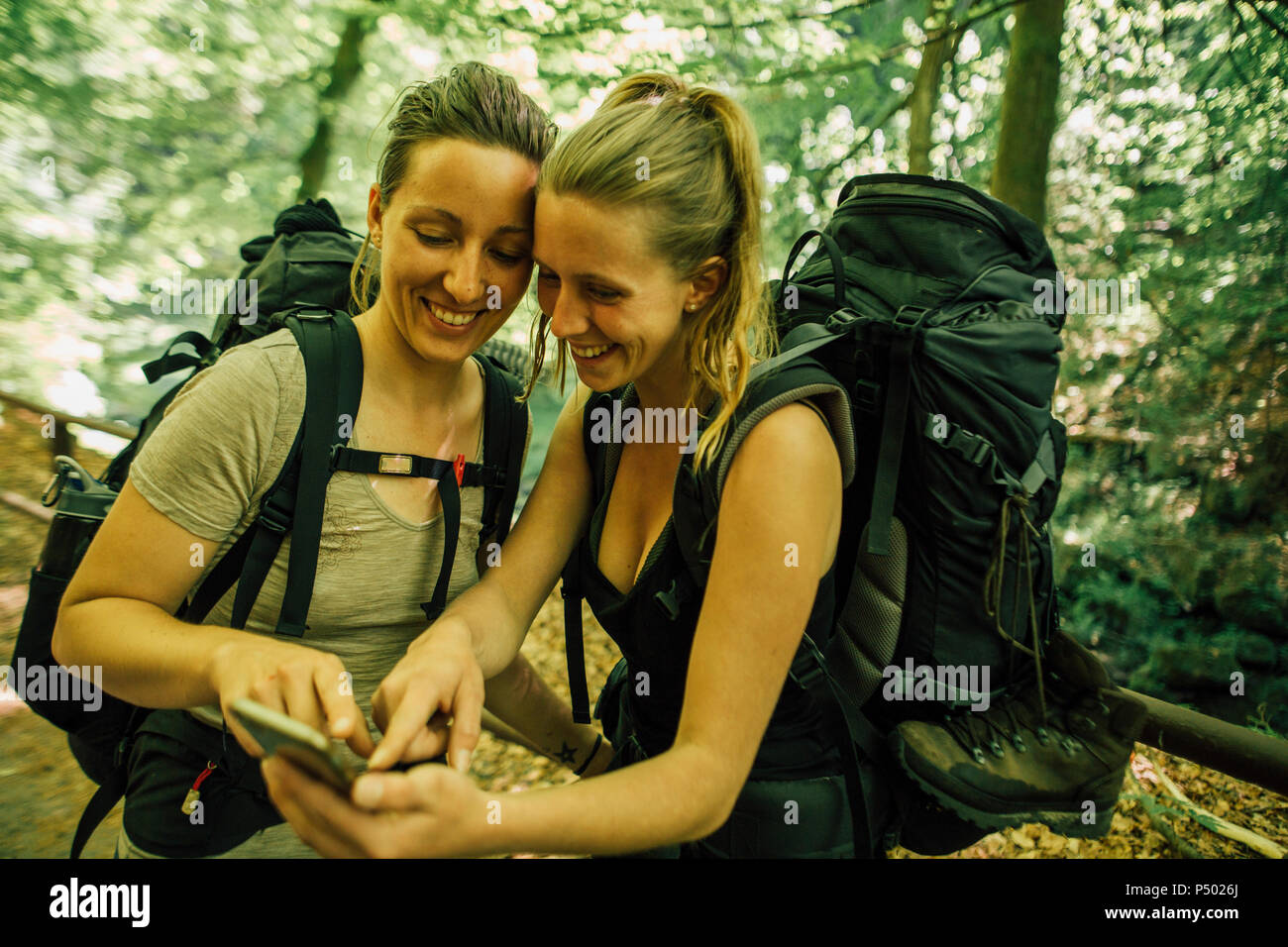 Due giovani felici donne su una escursione tramite telefono cellulare Foto Stock