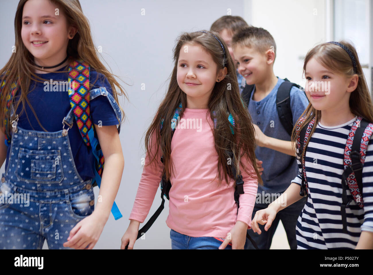 Gli alunni sorridente sul corridoio che lasciano la scuola Foto Stock