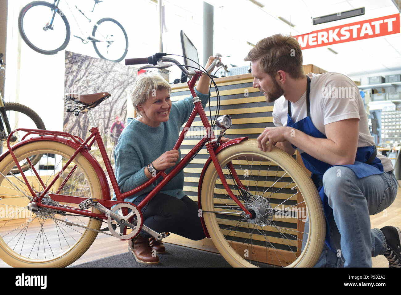 Addetto alle vendite ad aiutare il cliente nel negozio di biciclette Foto Stock