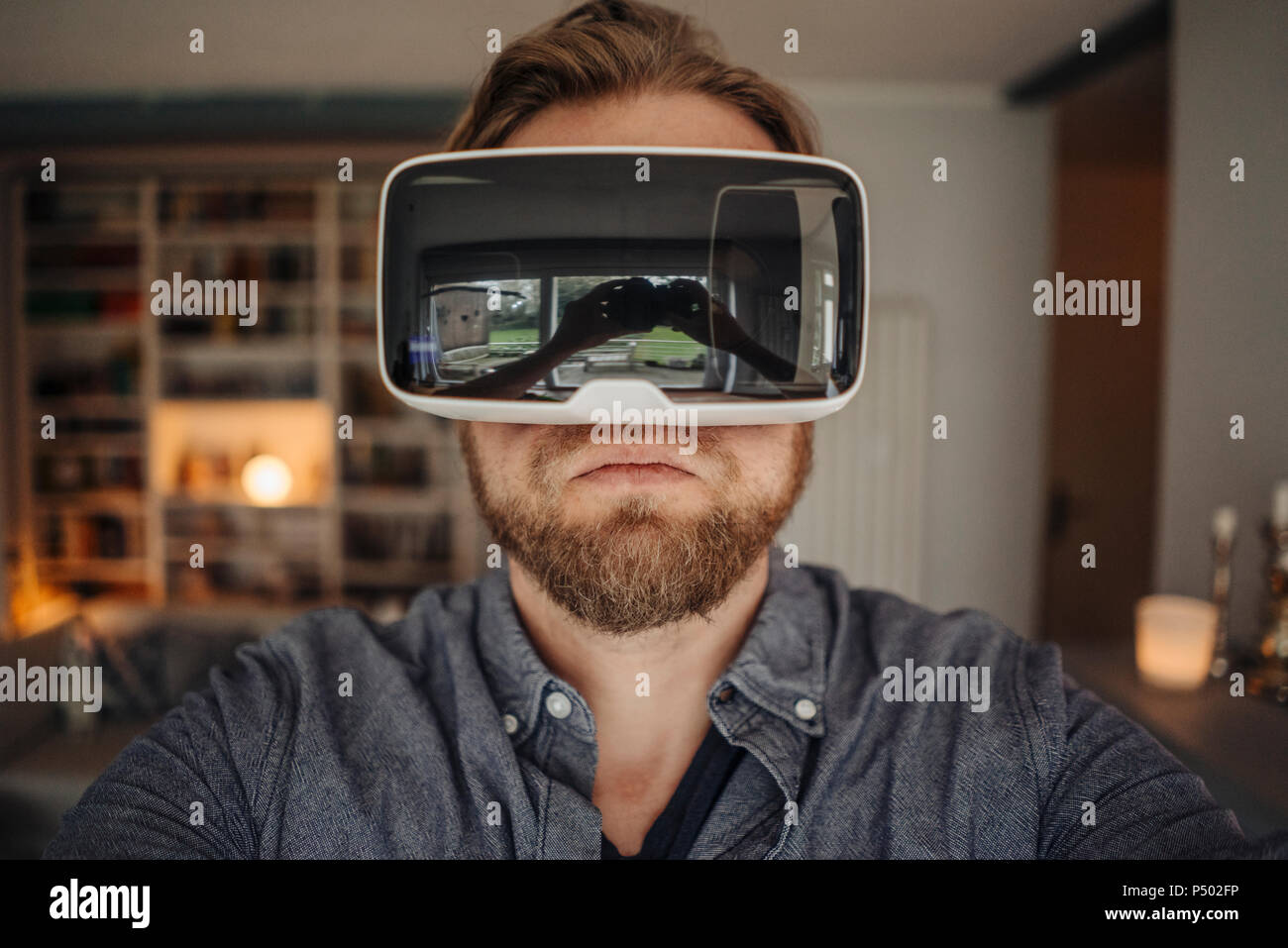 Uomo maturo tenendo selfie di se stesso, indossando occhiali VR, alla moda Foto Stock