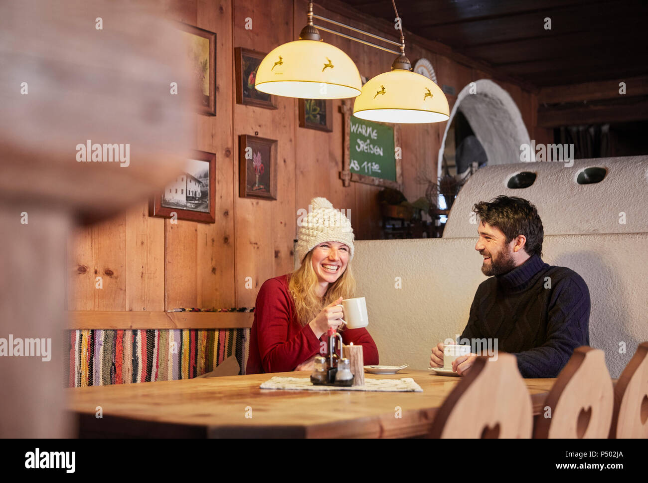 Coppia felice di bere una bevanda calda in stile rustico rifugio di montagna Foto Stock