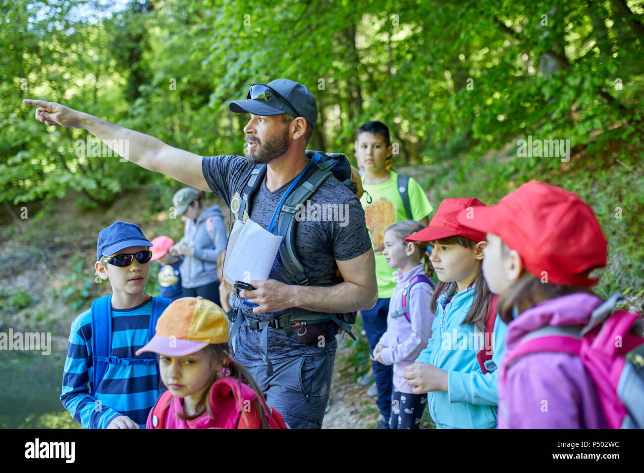 Uomo che parla di bambini in gita in foresta Foto Stock