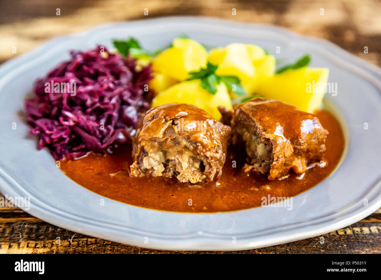 Involtini di carne con patate e cavolo rosso sulla piastra Foto Stock